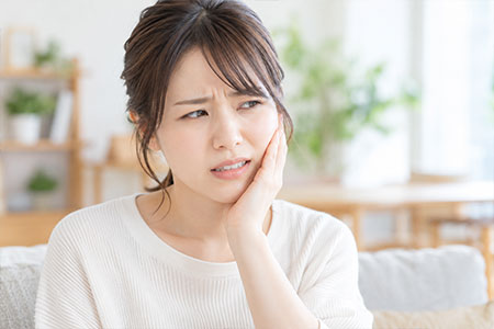 歯に痛みを感じる女性